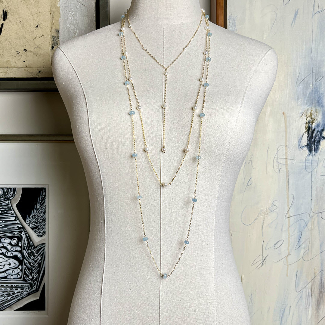 Three long layering chains in 14K gold fill, pearls and aquamarines, displayed on mannequin