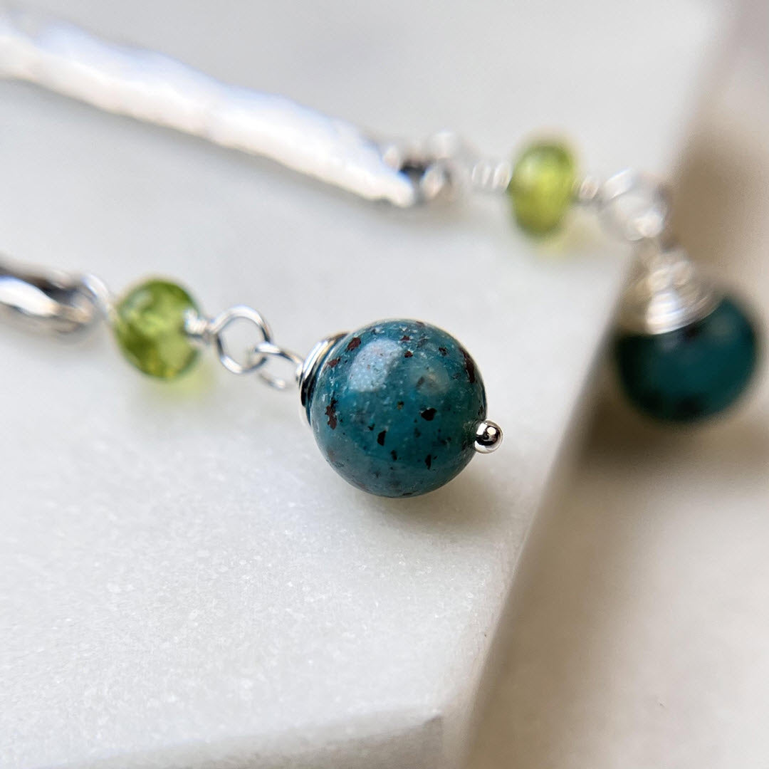 Close-up of chrysocolla and peridot sticks and stones earrings, sterling silver